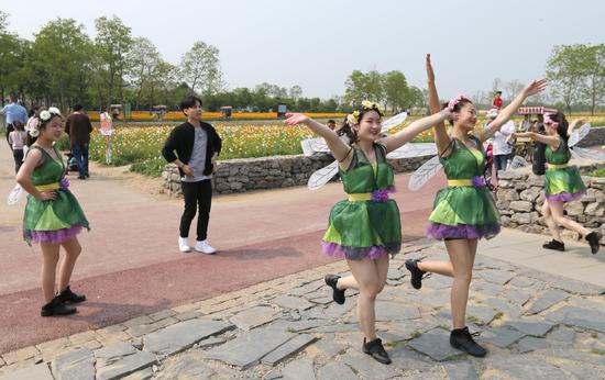 Girls dressed like dragonflies perform dances inspired by Douyin at a park in Suqian, Jiangsu province. (Photo by Zhou Guoqiang/For China Daily)