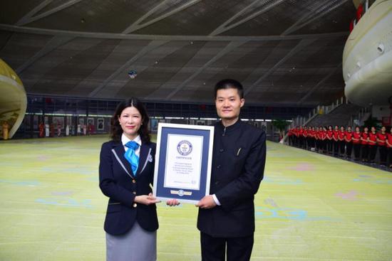  Kuang Xianpeng receives a Guinness World Records certificate.  (Photo provided to chinadaily.com.cn)