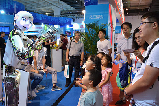 Delighted children and adults watch the performance of a robot at the 2017 China Beijing International High-Tech Expo on June 8. （Photo/China Daily）