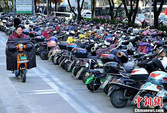 A woman rides an electric bike in Beijing. （Photo/China News Service）