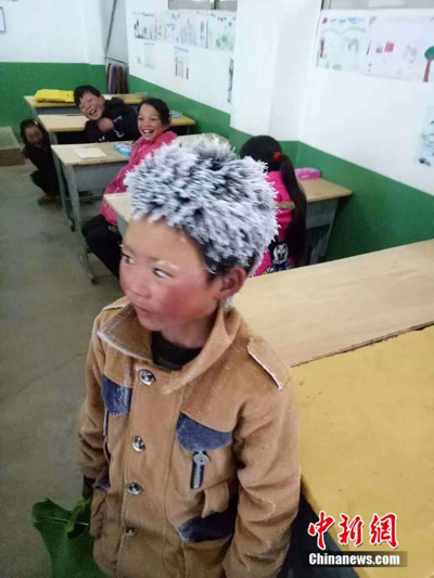 A third-grade boy at Zhuanshanbao Elementary School in Xinjie Town, Zhaotong City of Yunnan Province arrives at a classroom with his hair and eyebrows fully covered with frost. (Photo provided to China News Service)