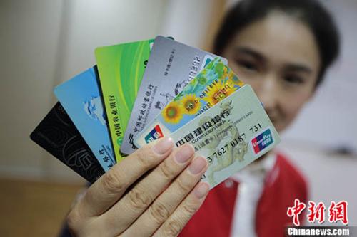 A woman shows her bank cards. (Photo/China News Service)