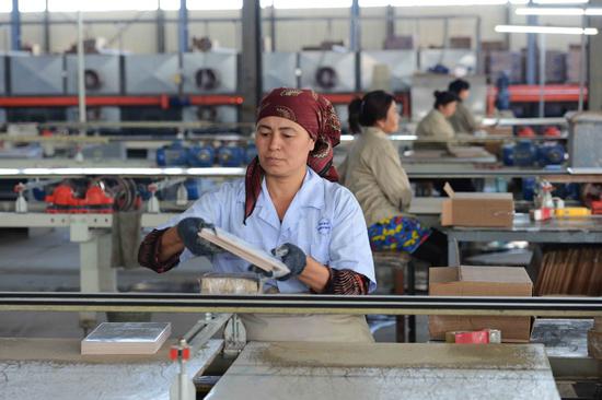 A local employee works on a ceramic tile production line at an industrial park, the first China-invested joint venture industrial park, in Uzbekistan. (Photo/Xinhua)