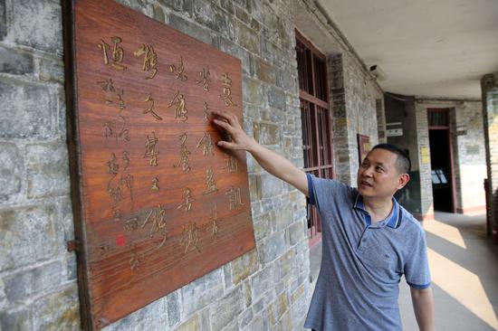 Yuan Yuxiao introduces an item exhibited in his museum. (WANG ZHUANGFEI/CHINA DAILY)