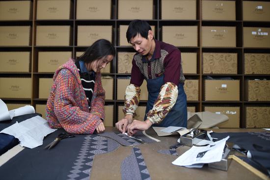 A Chinese garment designer (right) in Hangzhou, Zhejiang province, tailors a sample for his company's customers in Russia via cross-border e-commerce platform AliExpress. (Photo by Huang Zongzhi/Xinhua)