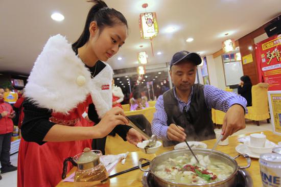 A waitress serves fish at a restaurant in Suzhou, East China's Jiangsu Province.  (Photo provided to China Daily)