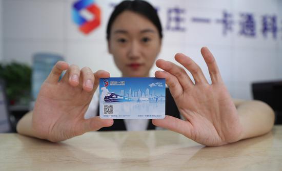 A worker shows a new transit card in Shijiazhuang, Hebei Province, on June 4, 2018. (Photo/Xinhua)