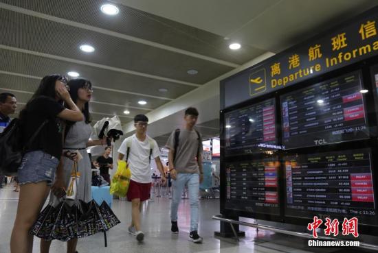 Passengers check information at the Sanya Phoenix International Airport, Hainan Province.  (Photo/China News Service)