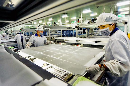 Two women work on a production line for a solar panel making company in Shangrao, Jiangxi Province. (Photo/China Daily)