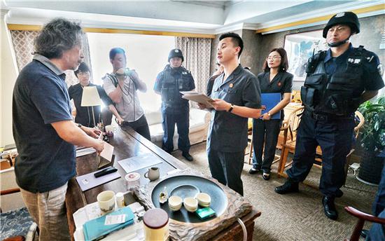 Judges and police officers enforce a court verdict at a defaulter's office in Beijing on Tuesday. (Photo/Legal Evening News)