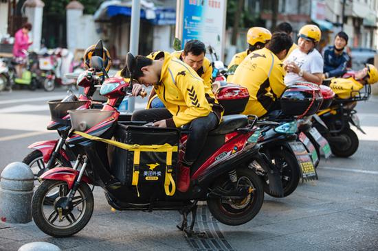 Food delivery drivers wait for orders on a street in Ningbo, Zhejiang Province.  (Photo by Jia Dongliu/For China Daily)
