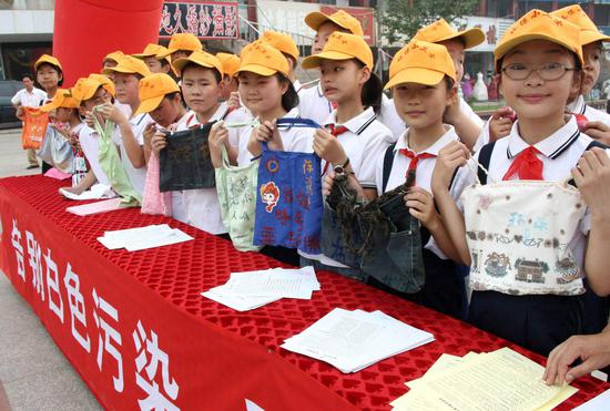 File photo taken on June 1, 2008 shows pupils displaying hand-made shopping bags in Hanshan, a county of east China's Anhui Province. (Xinhua/Cheng Qianjun)