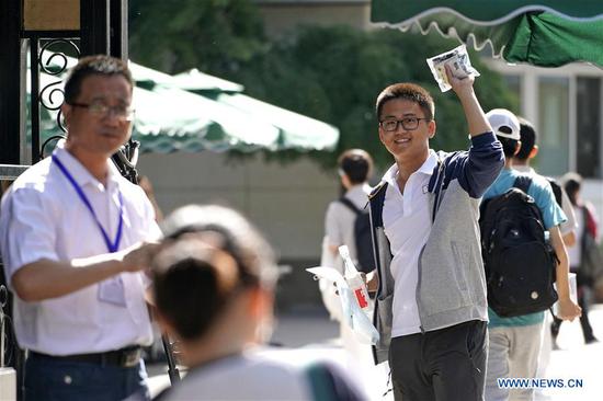 An examinee waves to his family at the exam venue at Beijing No. 4 High School in Beijing, capital of China, June 7, 2018. About 9.75 million students have registered for the national college entrance examination, which takes place from June 7 to 8. (Xinhua/Shen Bohan)