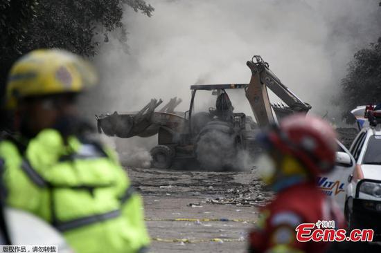 Rescuers use a backhoe loader to clear a street at the ash-covered village of San Miguel Los Lotes, in Escuintla department, about 35 km southwest of Guatemala City, June 4, 2018. (Photo/Agencies)