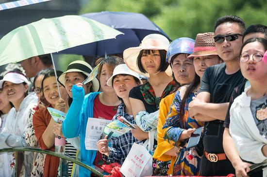 Parents and family members await students outside the entrance to an examination site in Haian, Jiangsu Province, during the annual national college entrance exams on Thursday. It was the first of two days of testing across the country. (Xu Jinbai/For China Daily)