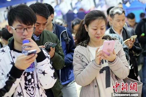 People read information on their mobile phones. (Photo/China News Service)