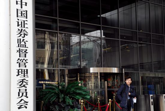 A pedestrian stands next to the China Securities Regulatory Commission office building in Beijing. (Photo provided to China Daily)