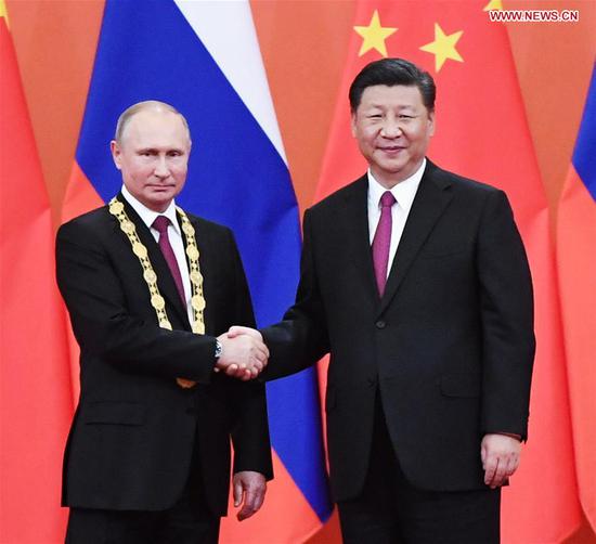 Chinese President Xi Jinping awards his Russian counterpart Vladimir Putin the first-ever Friendship Medal of the People's Republic of China at the Great Hall of the People in Beijing, capital of China, June 8, 2018. (Xinhua/Shen Hong)