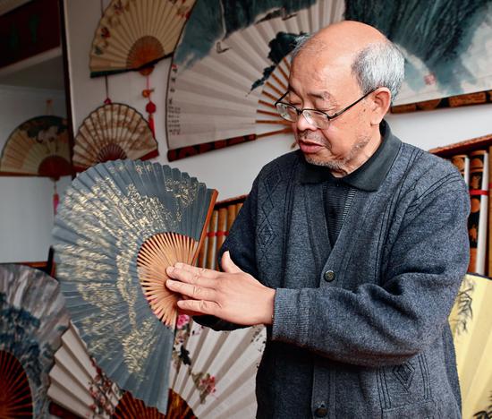 Chen Zifu, who was born into a fan-making family in Rongchang, promotes the traditional technique of making Rongchang folding fans.  (Photo/China Today)
