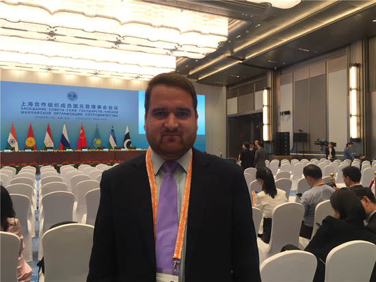 Wajid Khan, a reporter from Independent News Pakistan, poses for a photo in Qingdao for the 18th Shanghai Cooperation Summit, June 10, 2018. (Photo by Guo Rong/chinadaily.com.cn)