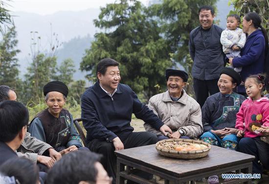 Xi Jinping talks with local villagers and cadres at Shibadong village in Paibi township of Huayuan county in the Tujia-Miao autonomous prefecture of Xiangxi, Central China's Hunan Province, Nov. 3, 2013. (Photo/Xinhua)