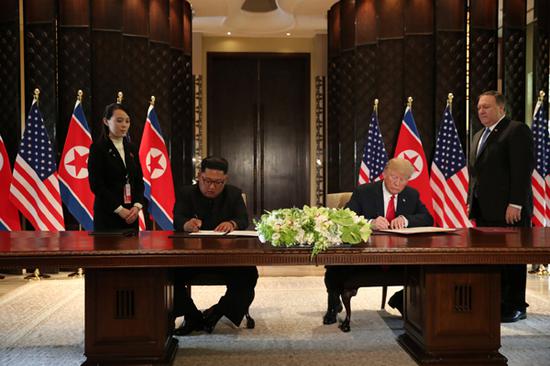 U.S. President Donald Trump (R) and top leader of the Democratic People's Republic of Korea (DPRK) Kim Jong Un sign documents that acknowledge the progress of the talks and pledge to keep momentum going, after their summit at the Capella Hotel on Sentosa island in Singapore, June 12, 2018.  (Photo/Agencies)