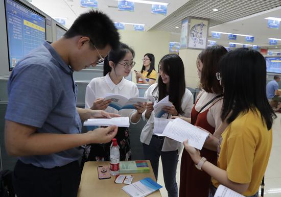 Job applicants (right) consult representatives of an employer at a job fair on the sidelines of the Straits Forum in Xiamen, Fujian province, on Saturday.  (Chen Lijie/For China Daily)