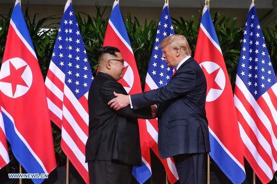 Top leader of the Democratic People's Republic of Korea (DPRK) Kim Jong Un (L) shakes hands with U.S. President Donald Trump in Singapore before the first-ever DPRK-U.S. summit, on June 12, 2018. (Xinhua/The Straits Times)