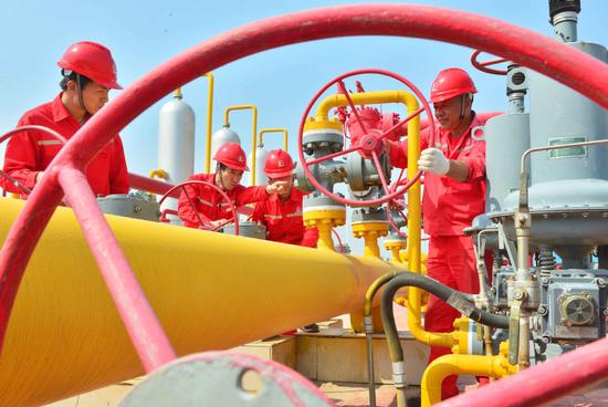 Technology staff of China Petroleum & Chemical Corporation inspect production facilities in Puyang, Central China's Henan Province. (Photo by Tong Jiang / for China Daily)