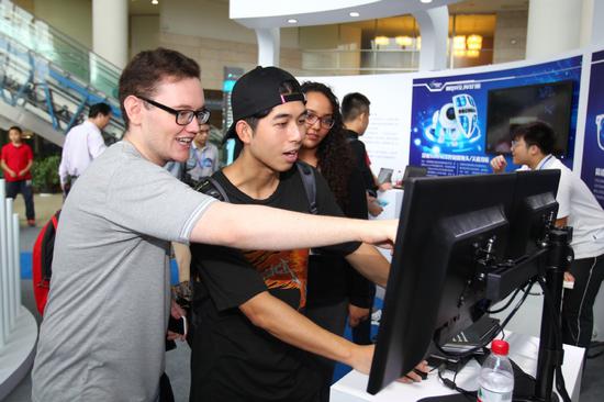Visitors look at a demonstration of cybersecurity protection tools at a cybersecurity protection exhibition for youth in Shanghai on Sept. 23, 2017. (Photo/Xinhua)