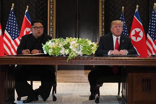 U.S. President Donald Trump (R) and top leader of the Democratic People's Republic of Korea (DPRK) Kim Jong Un sign documents that acknowledge the progress of the talks and pledge to keep momentum going, after their summit at the Capella Hotel on Sentosa island in Singapore, June 12, 2018.  (Photo/Agencies)