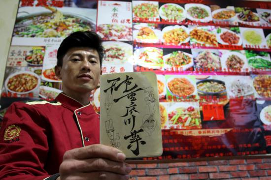 Liang Yangyang, the cofounder of Wusheng Restaurant, displays the menu.  (Photo by Zheng Tao/For China Daily)
