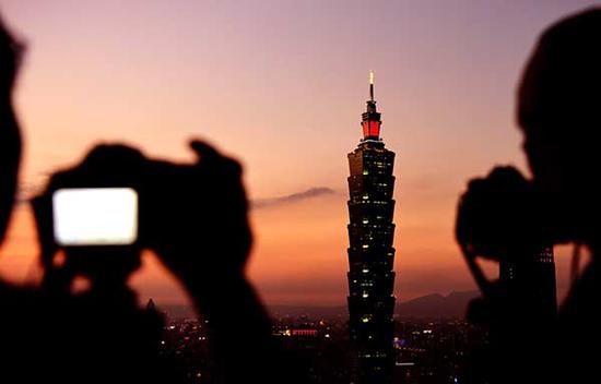 People take photos of the landmark Taipei 101 building in Taiwan in January 2017. (Photo/Xinhua)