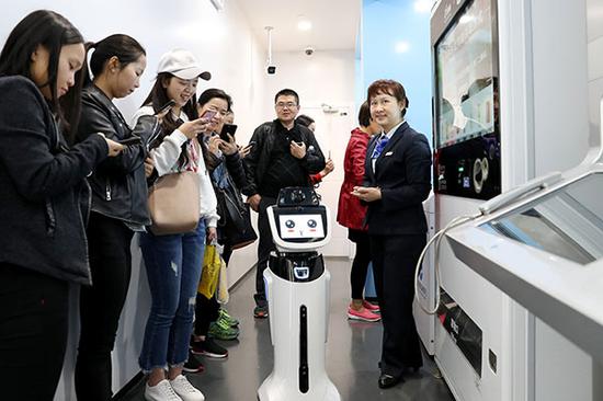 A robot helps provide banking services at a bank outlet in Shanghai. (Photo/Xinhua)