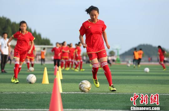 Mo Qiu, from Guizhou Province, a flag-bearer of the opening ceremony of  2018 World Cup, practices in the football field. (Photo/China News Service)