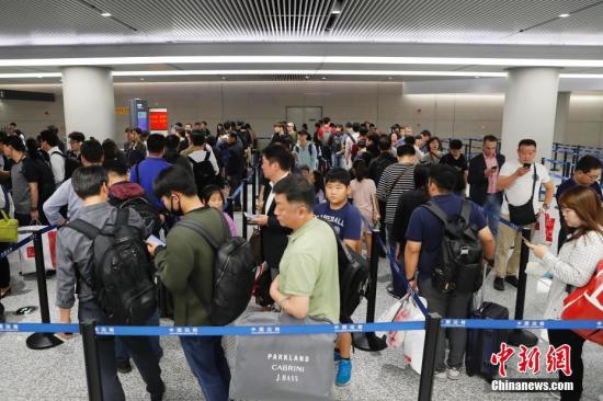 People wait to pass through a customs checkpoint. (File photo/China News Service)