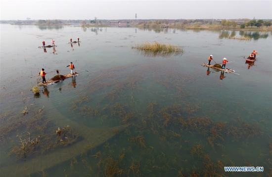 Sanitation staff work at the Gonghuwan wetland park in Wuxi, a city of Taihu Lake basin in east China's Jiangsu Province, Dec. 7, 2017. China rolled out a 