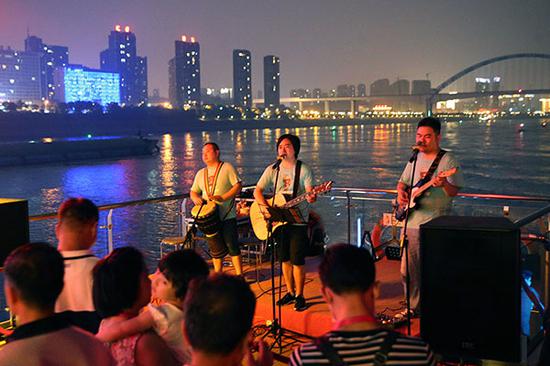 A band performs on the boat's upper deck.(Photo by Wang Zhuangfei/China Daily)