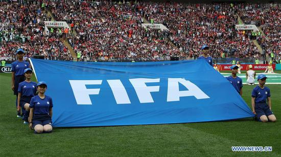 Chinese caddies hold FIFA flag before opening match of 2018 FIFA World Cup