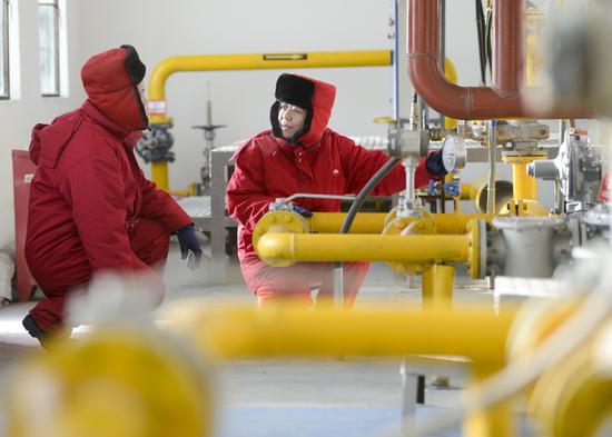 Technicians at Petro China's Xinjiang Oilfield Company make routine checks of equipment in early February in Karamay, Xinjiang Uygur autonomous region. (Photo by Zhao Ge/Xinhua)