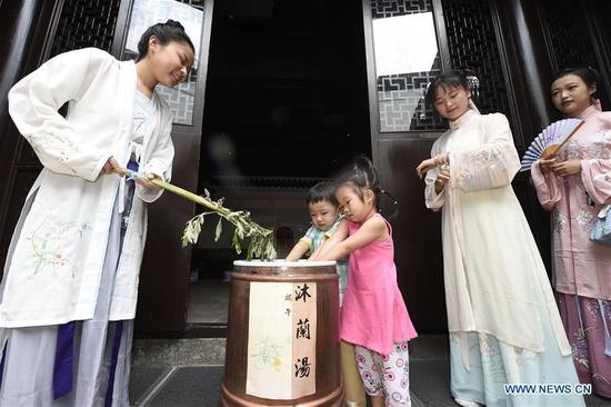 Children experience traditional customs at the Museum of Hangzhou Local Chronicles in Hangzhou, capital of east China's Zhejiang Province, June 17, 2018. People enjoy their holiday time during the Dragon Boat Festival. (Xinhua/Li Zhong)