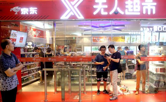 Shoppers at an unmanned supermarket of JD in Beijing. (Photo by Wang Jing/China Daily)