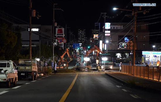 Workers work at a site of a damaged road in Osaka, Japan, on June 18, 2018. At least three people have been confirmed dead and more than 90 others injured as a result of a 6.1 magnitude earthquake striking Osaka prefecture in western Japan on Monday morning. (Xinhua/Ma Ping)