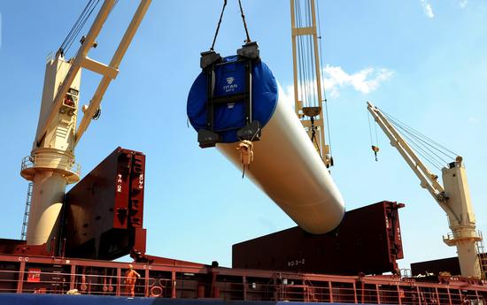 China-made wind power turbine equipment, which will be exported to Romania, is loaded onto a ship in Lianyungang, Jiangsu province. (Photo by Wang Chun/For China Daily)