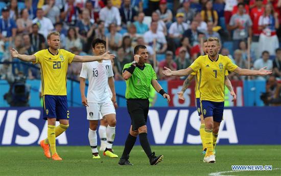 Referee (C) communicates with Video Assistant Referee (VAR) during a group F match between Sweden and South Korea at the 2018 FIFA World Cup in Nizhny Novgorod, Russia, June 18, 2018. Sweden won 1-0. (Xinhua/Yang Lei)