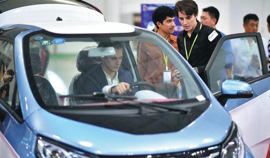Visitors take part in a new energy auto show in Haikou, South China's Hainan province. (Photo/Xinhua)