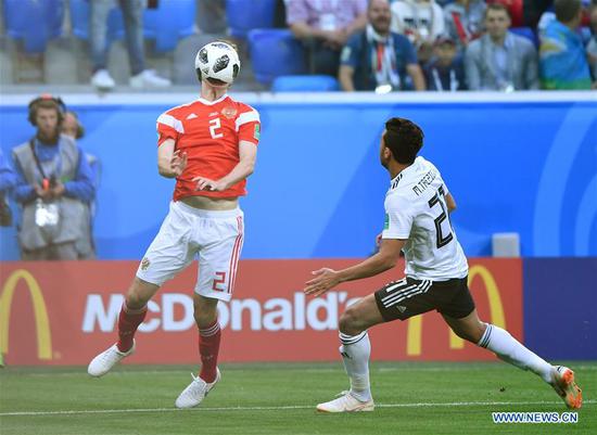 Mario Fernandes (L) of Russia vies with Trezeguet of Egypt during a Group A match between Russia and Egypt at the 2018 FIFA World Cup in Saint Petersburg, Russia, June 19, 2018. (Xinhua/Li Ga)