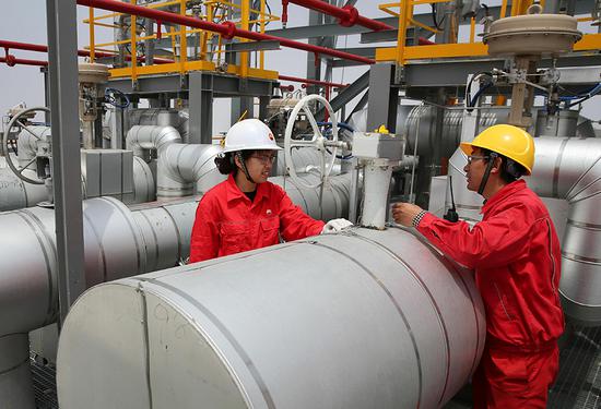 Technicians check liquefied natural gas facilities in Nantong, Jiangsu province. (Photo by Xu Congjun/For China Daily)