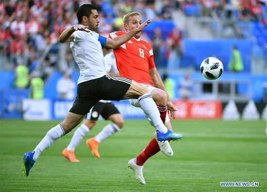 Iury Gazinsky (R) of Russia vies with Ahmed Fathi of Egypt during a Group A match between Russia and Egypt at the 2018 FIFA World Cup in Saint Petersburg, Russia, June 19, 2018. (Xinhua/Li Ga)