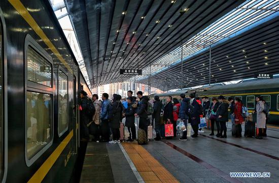 Passengers line up to board a train at the Beijing West Railway Station in Beijing, capital of China, Feb. 12, 2018. (Photo/Xinhua)